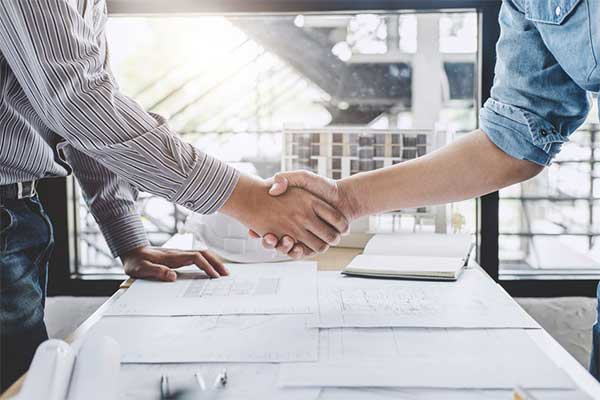 A Contractor’s Guide to IR35 - Part 2 - Contractor agreeing contract with client and shaking hands.