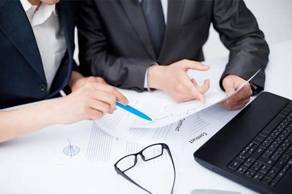 A Contractor’s Guide to IR35 - Part 3 - Businessmen pointing to document and discussing a contractor's IR35 status.