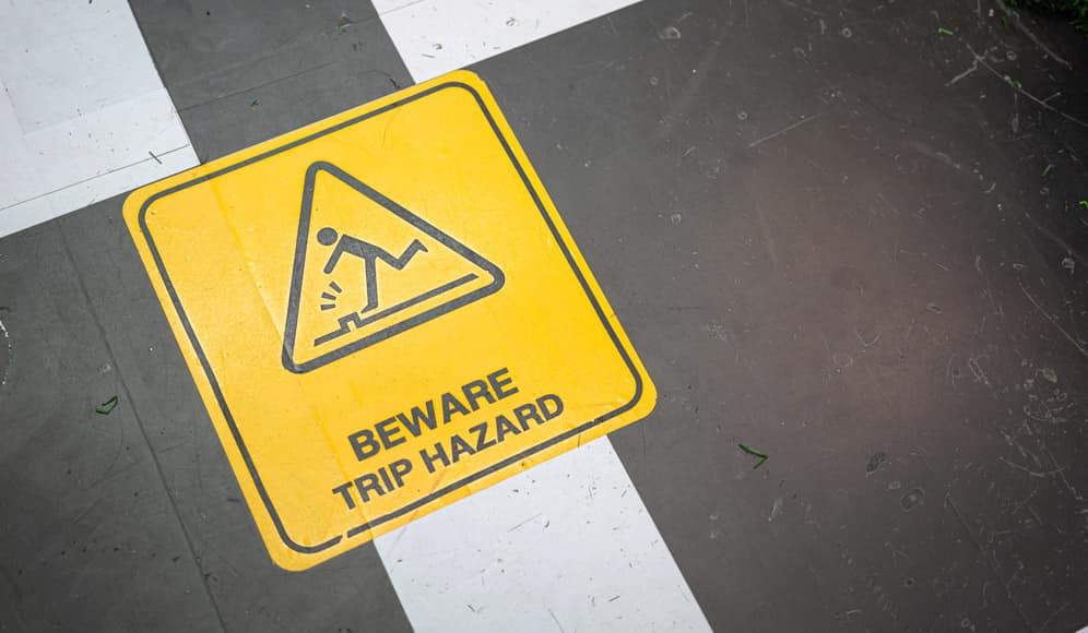 A floor sticker saying BEWARE TRIP HAZARD