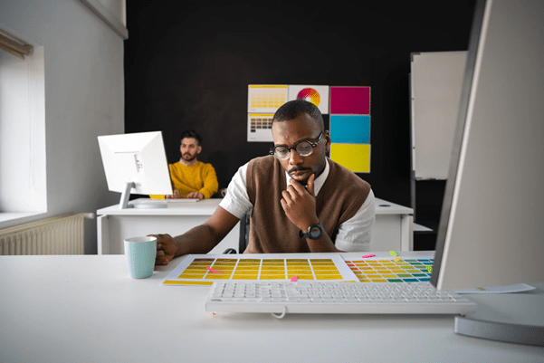 Someone sat at a desk looking at a range of branding colours