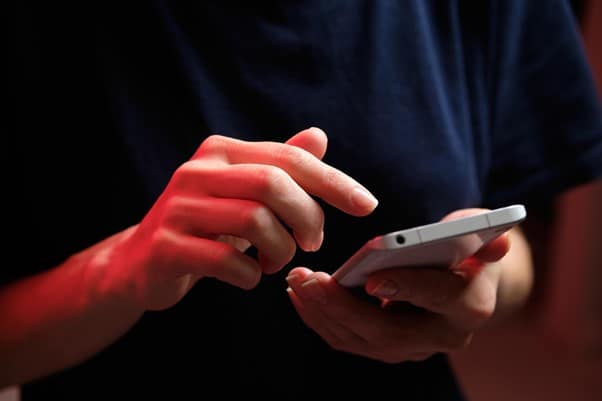 A hand holding a device with the other hand scrolling