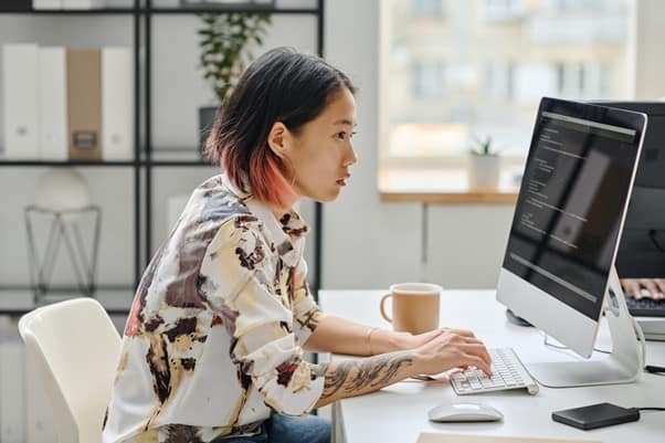 A side view of someone sat at a desk or the computer