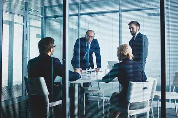 Company directors discussing strategy in meeting room.