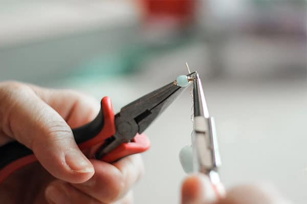 Person holding plyer to make jewellery