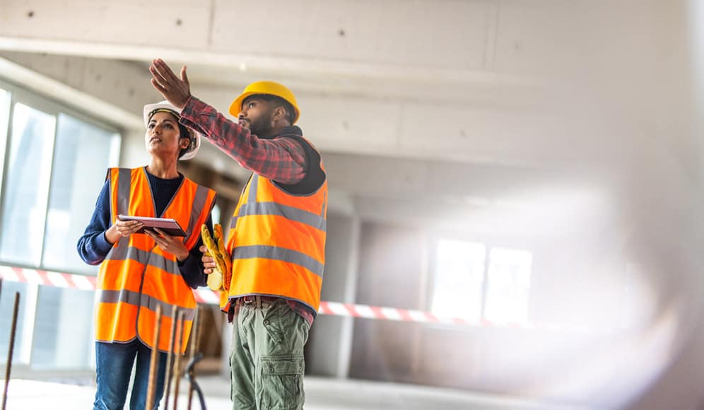 Two people on a construction site, assessing the environment