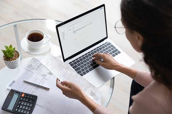 A self-employed woman sat at coffee table sorting out her tax bill.