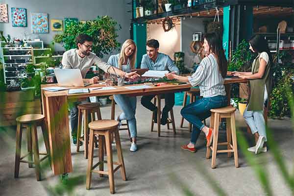 A freelancer and charity staff sat around a table working together. 