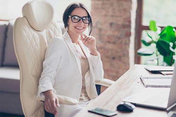 An estate agent sat at her desk on the phone to a client.