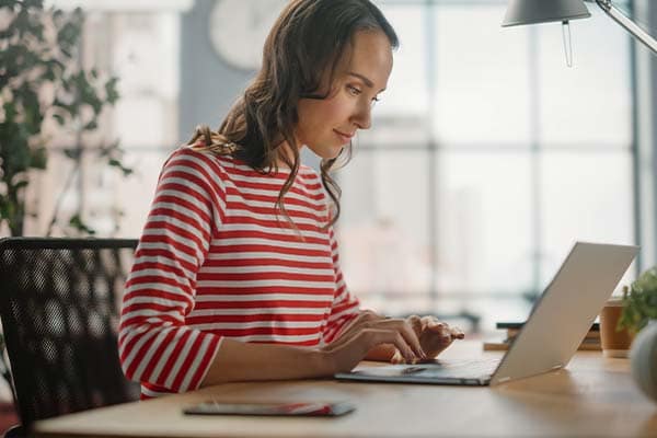 A freelancer sat at her desk working productively on her laptop.