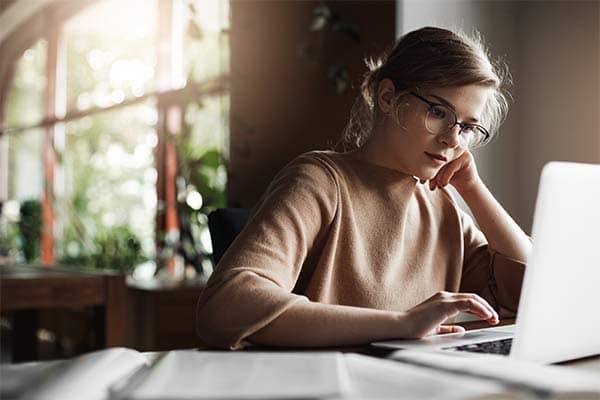 Freelance business owner sat at her desk working on a laptop.