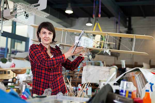 An online craft seller holding an aeroplane model.
