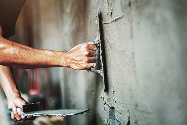 Close up of a plasterer's hands, plastering a wall.