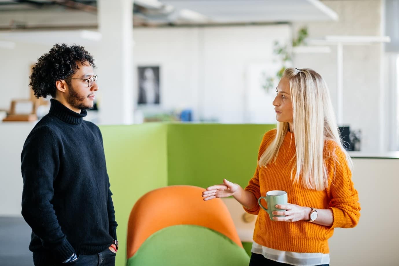 two people chatting in a colourful workspace