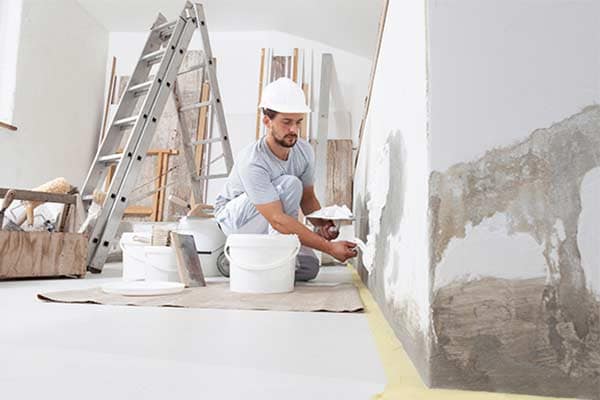 A painter working on a wall in a client's home.