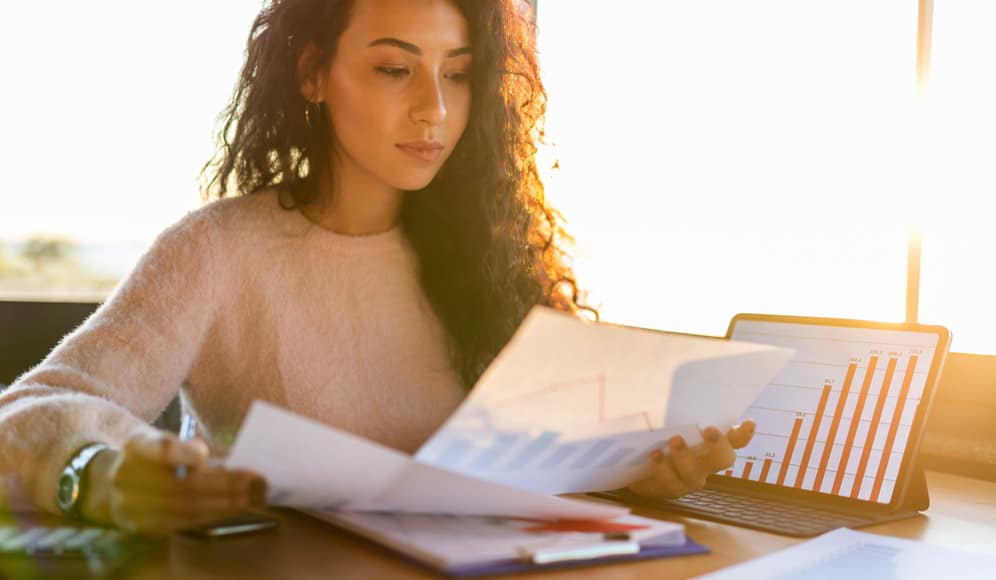 A person sat at a table looking through paperwork