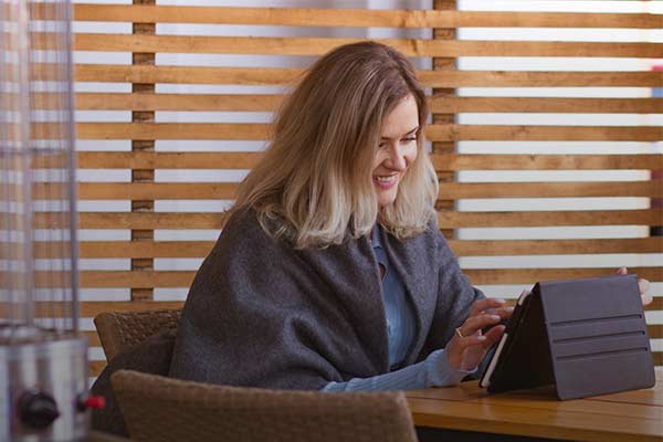 Small business owner sat at her desk working from an iPad.