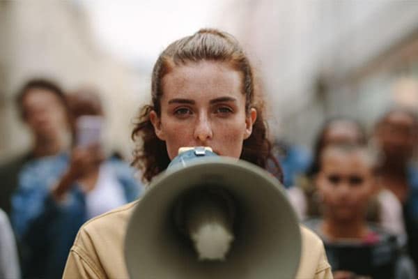 A female protester holding a megaphone.