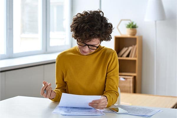 A self-employed freelance reading a financial statement.