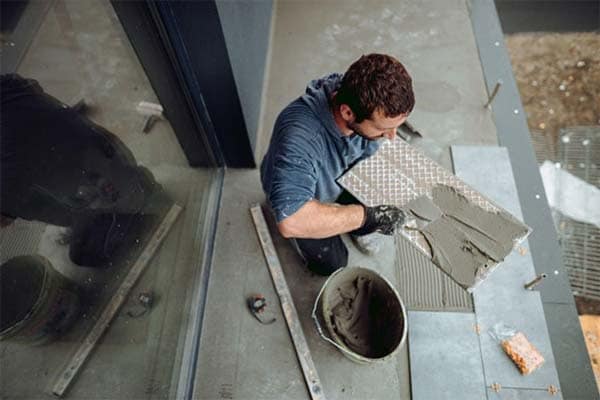 A tiler installing ceramic floor tiles.