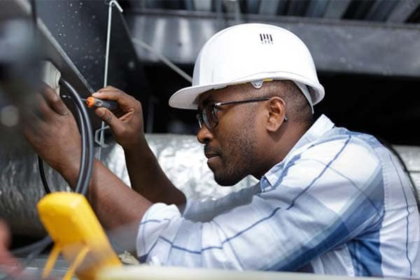 An electrician testing a domestic plug socket.
