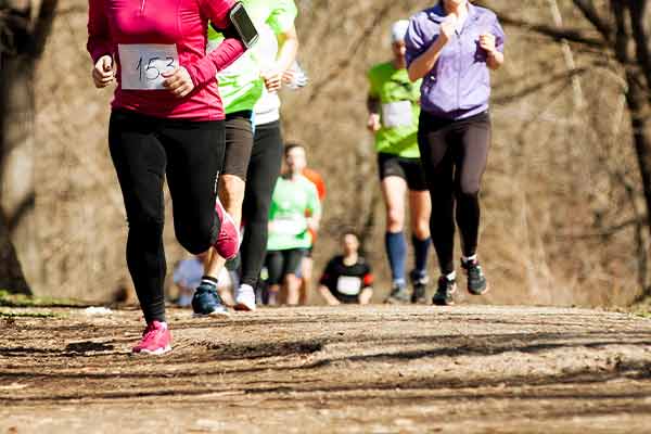 People participating in a charity event and running through the woods.