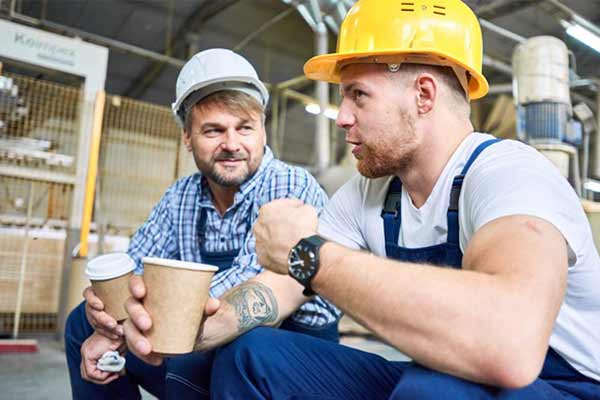 Two tradesman sat down having a chat over a cup of tea.