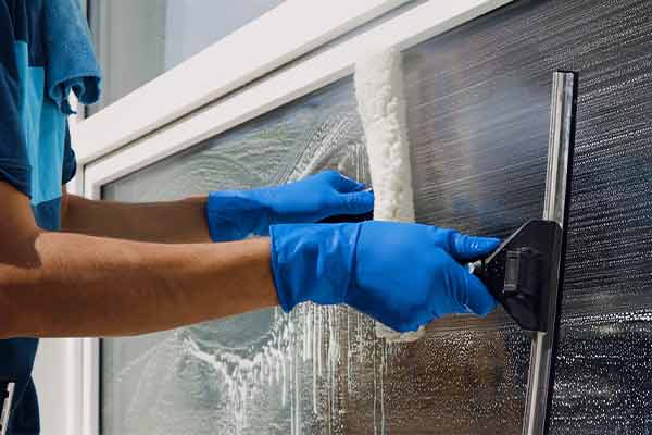 A window cleaner washing the glass in a window.