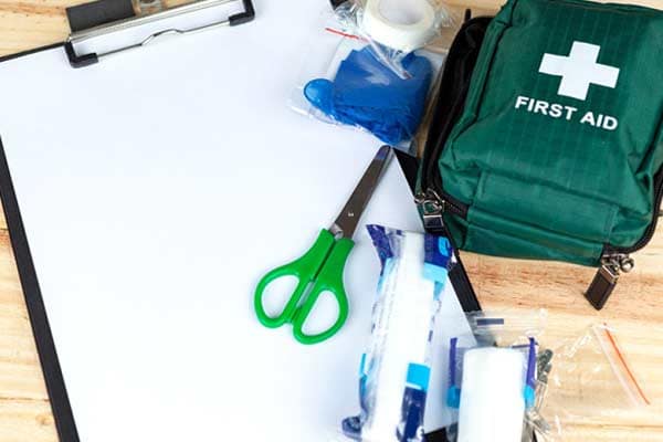 a first aid kit and clipboard on a table 
