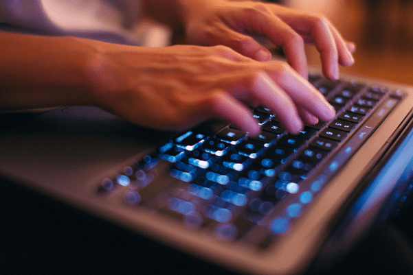 some hands typing on a computer