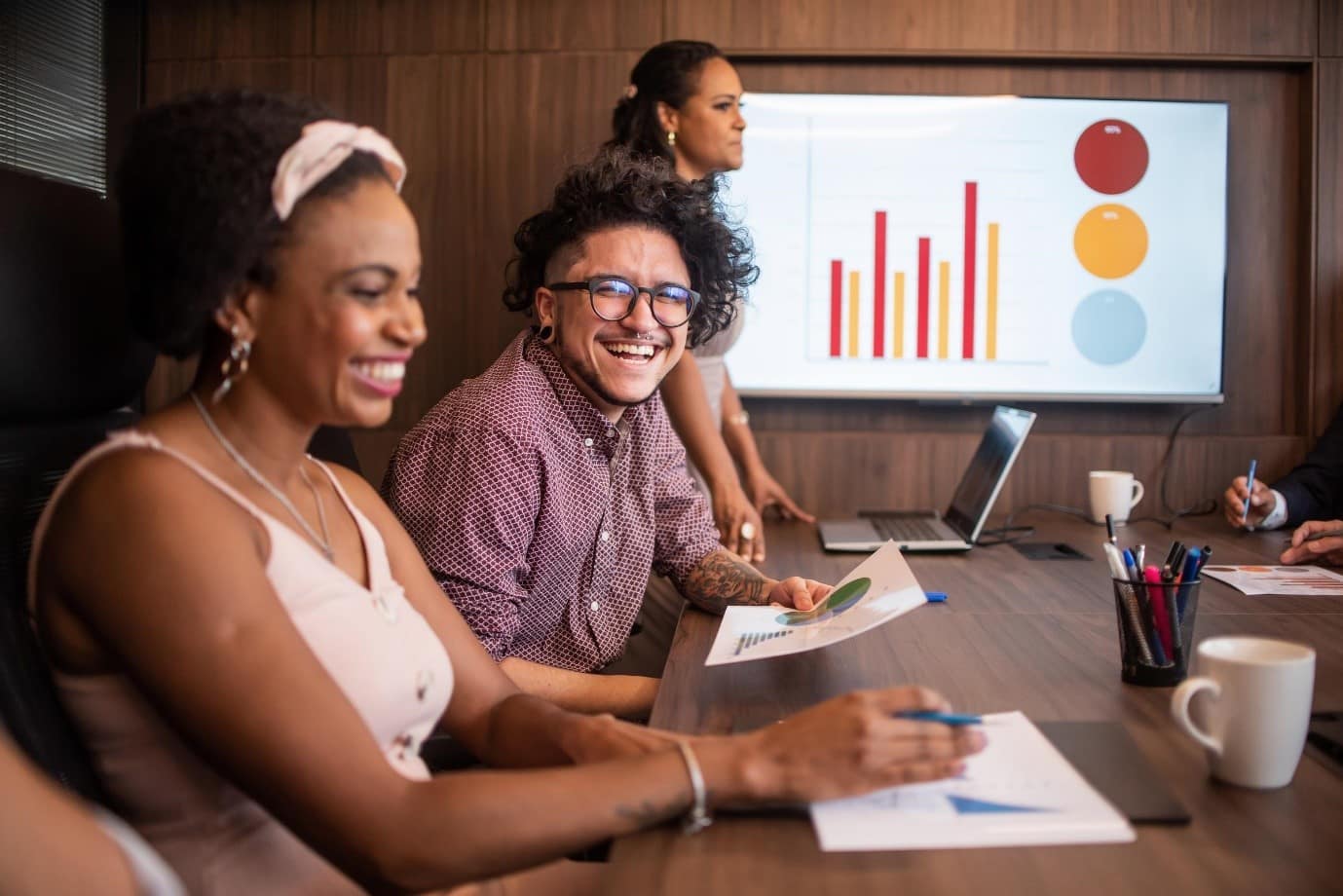 A group of people sat around a table looking over graphs and paperwork