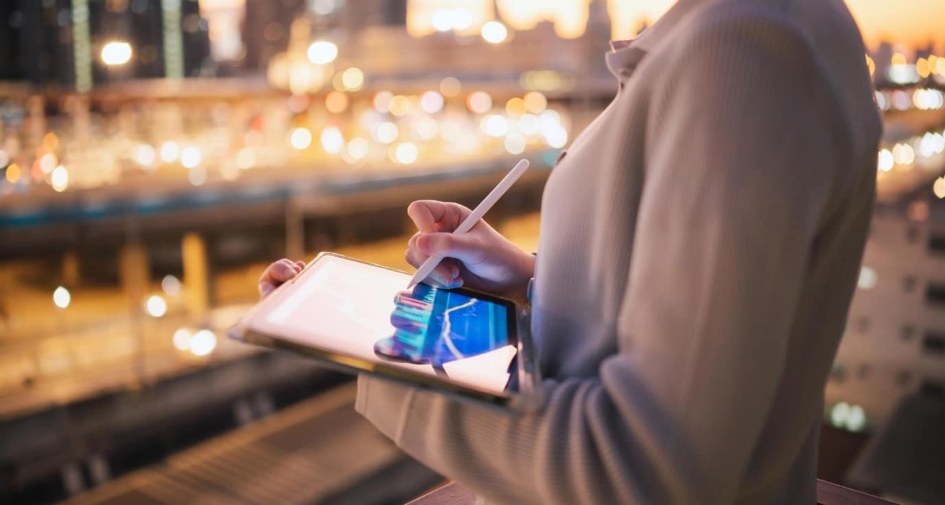 A side view of someone drawing graphs on an electronic tablet
