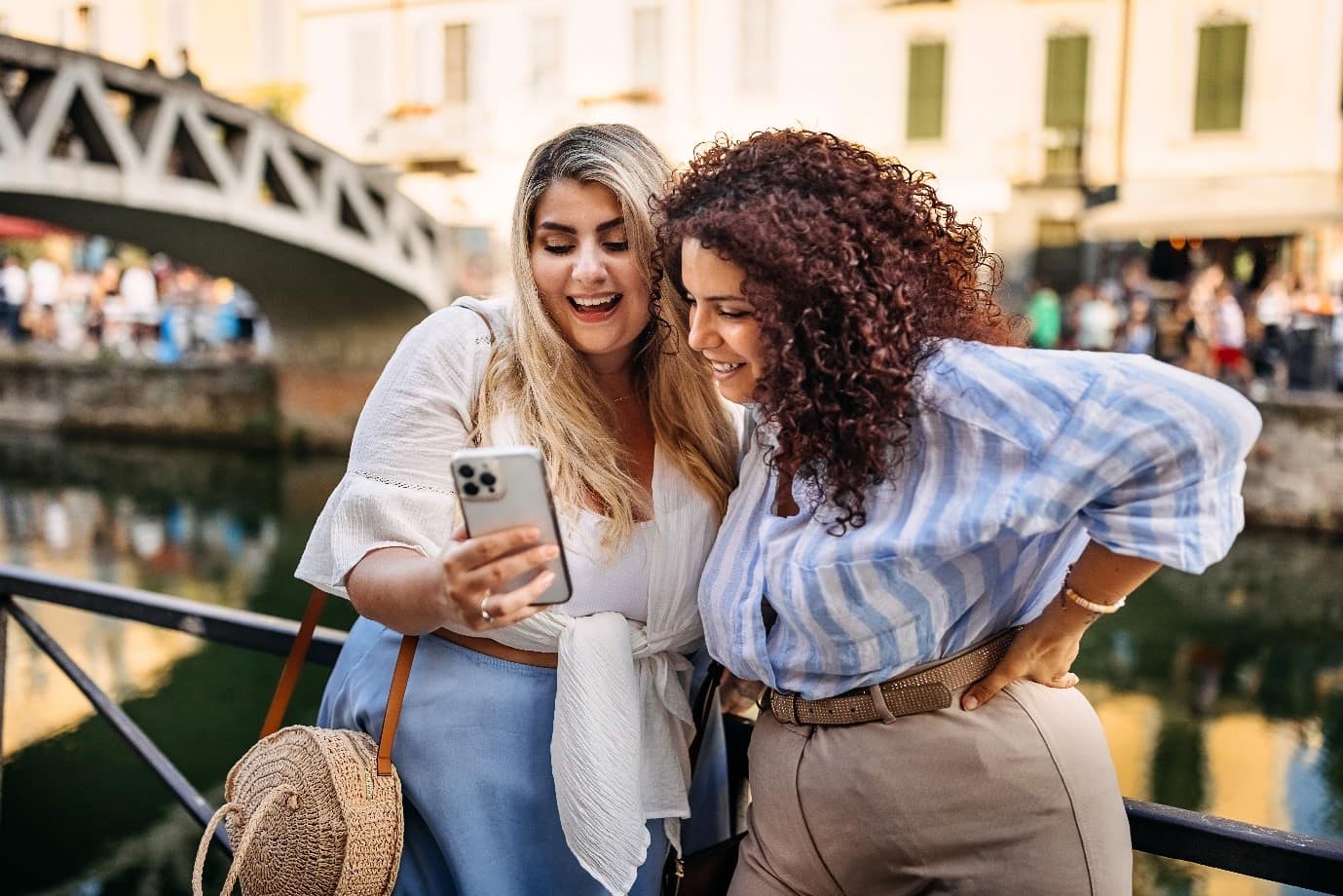 Two people stood infront of a river both smiling at a phone screen