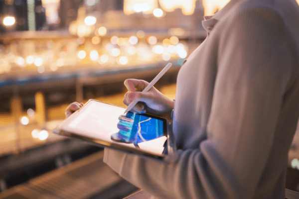 A side view of someone drawing graphs on an electronic tablet