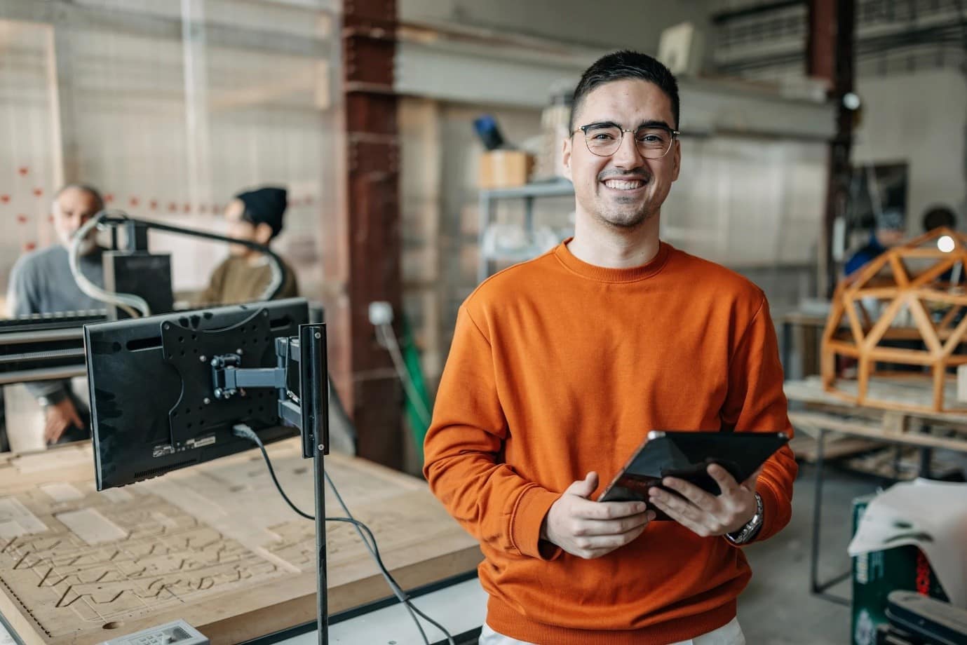 Someone stood holding an electronic tablet in a workshop