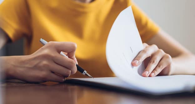 Woman studying contract with pen in hand