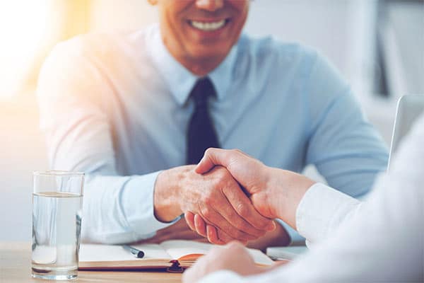 A small business owner shaking hands with a new employee.