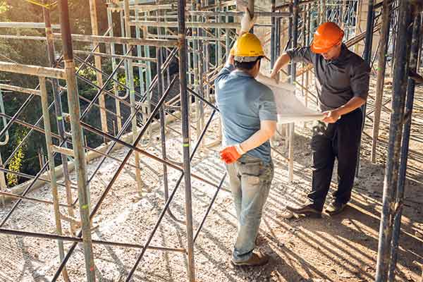 A builder on a construction site speaking to the project manager.