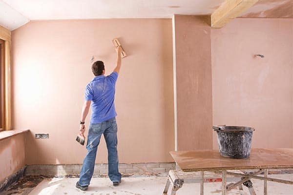 A plasterer working on a wall in a customer's home.