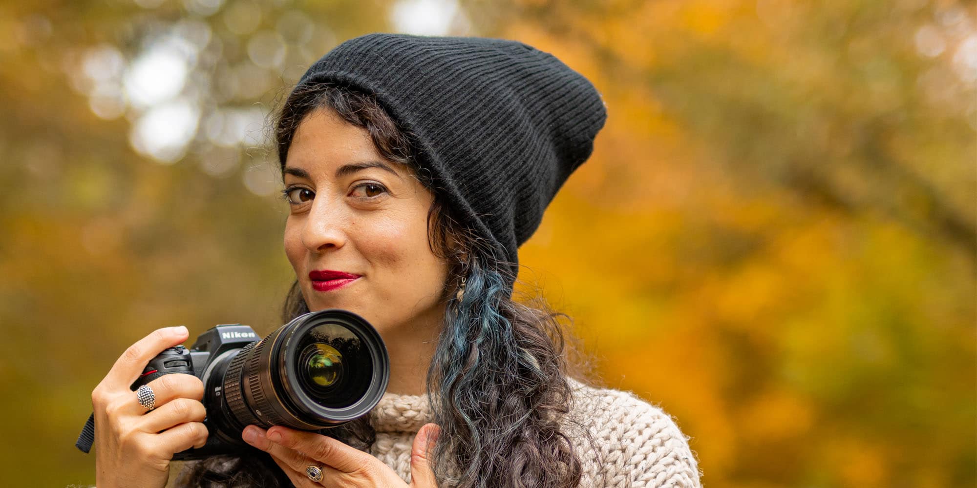Female photographer posing with camera
