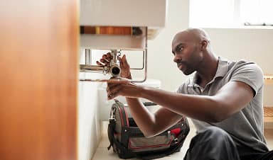 Plumber fixing a sink in customer home