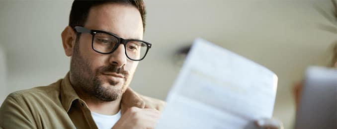 Man wearing glasses looking at a document