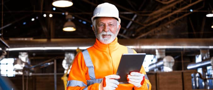 Self-employed construction worker using a tablet on a job site.