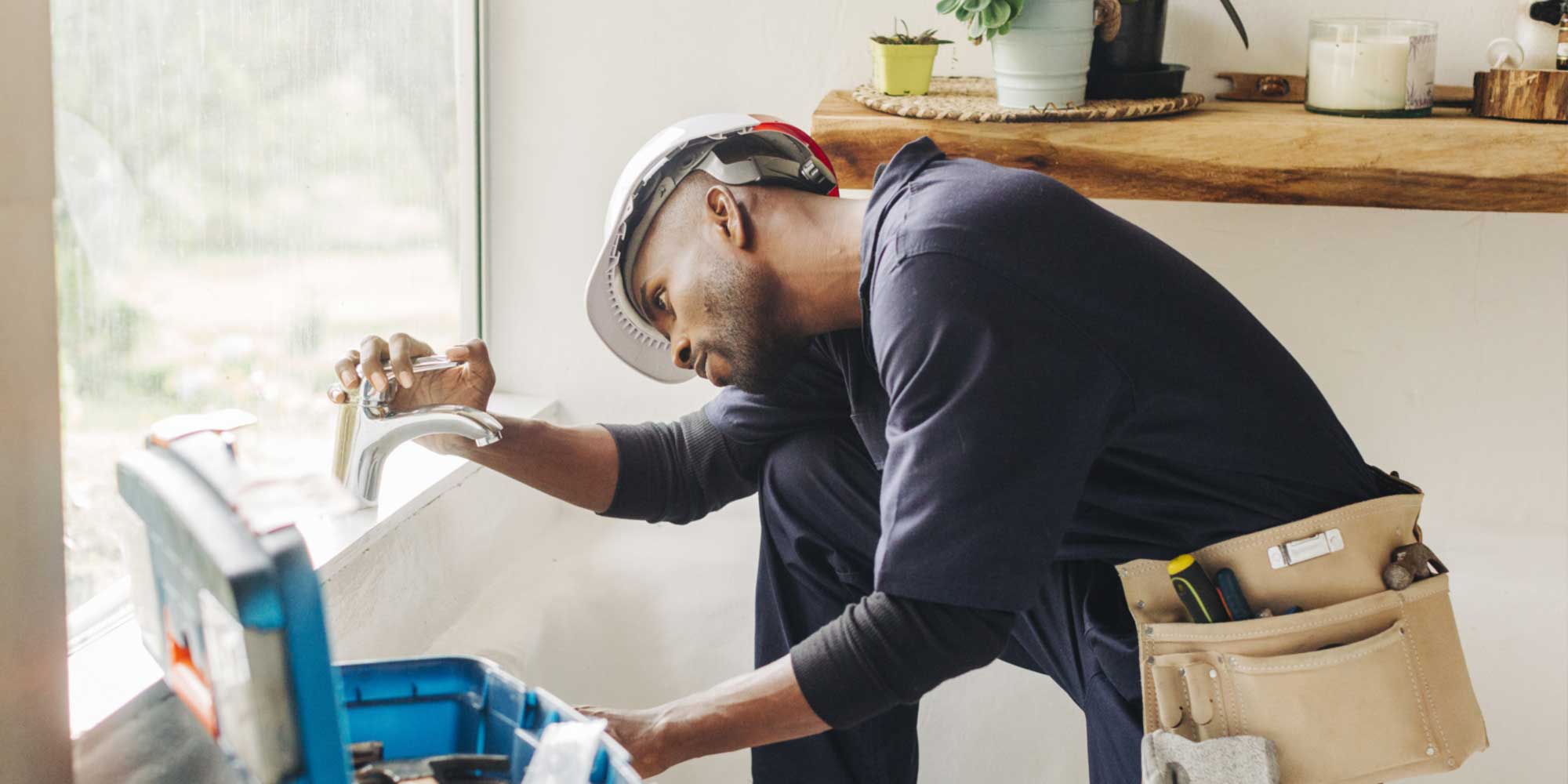 Man installing a faucet in a bathroom