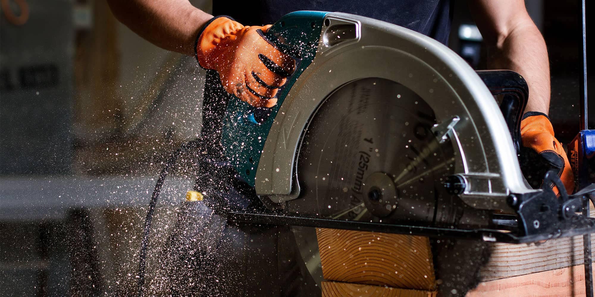 Hands using a circular saw to cut a piece of wood