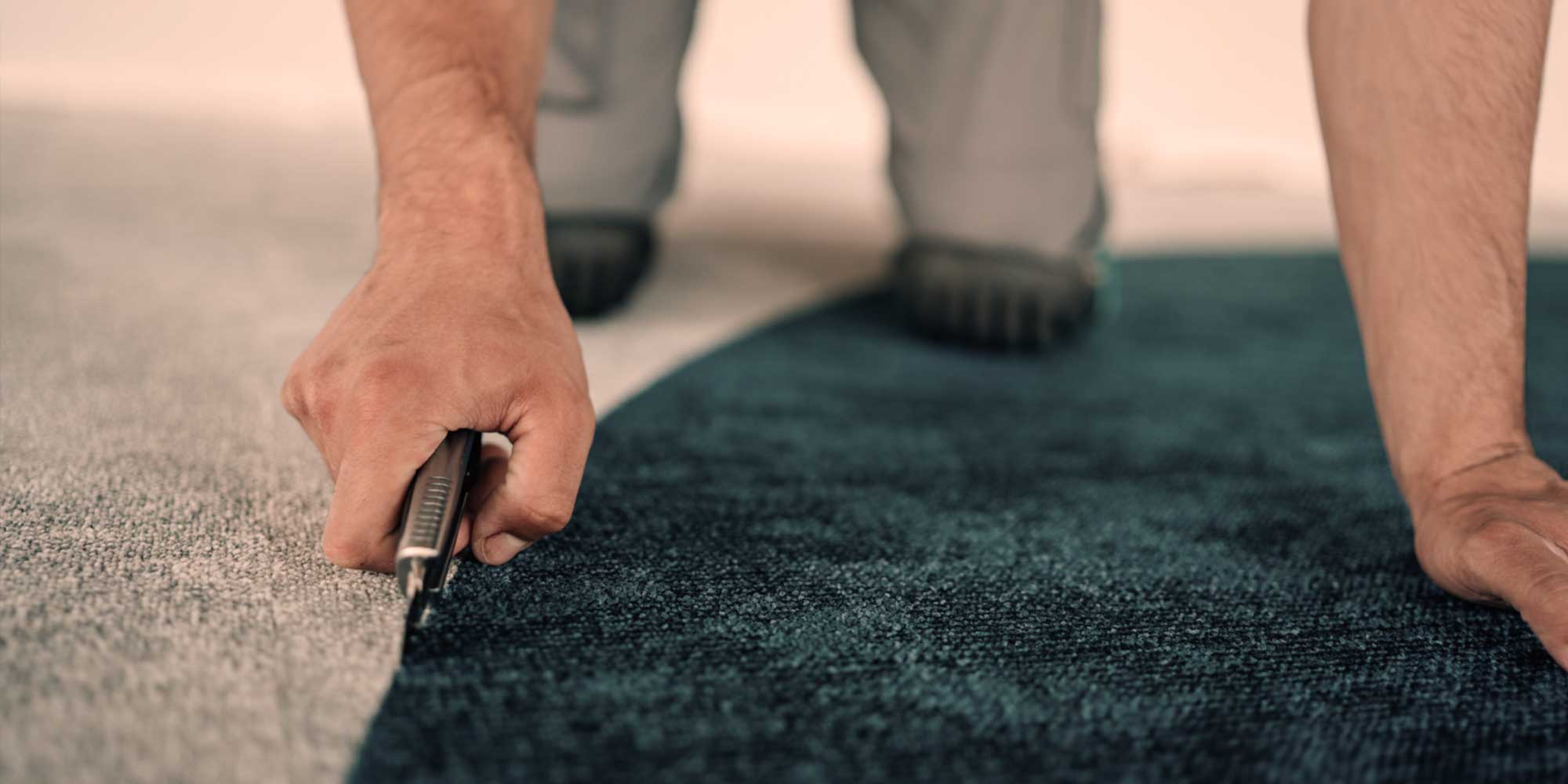 Man installing custom wall to wall carpeting