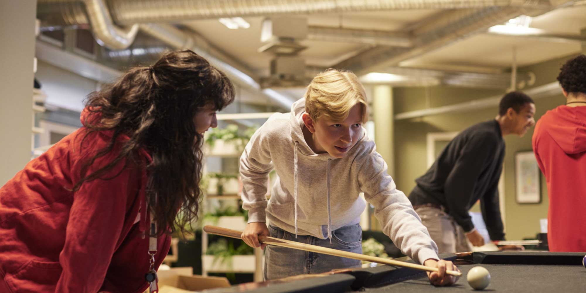 Teens at youth club playing pool