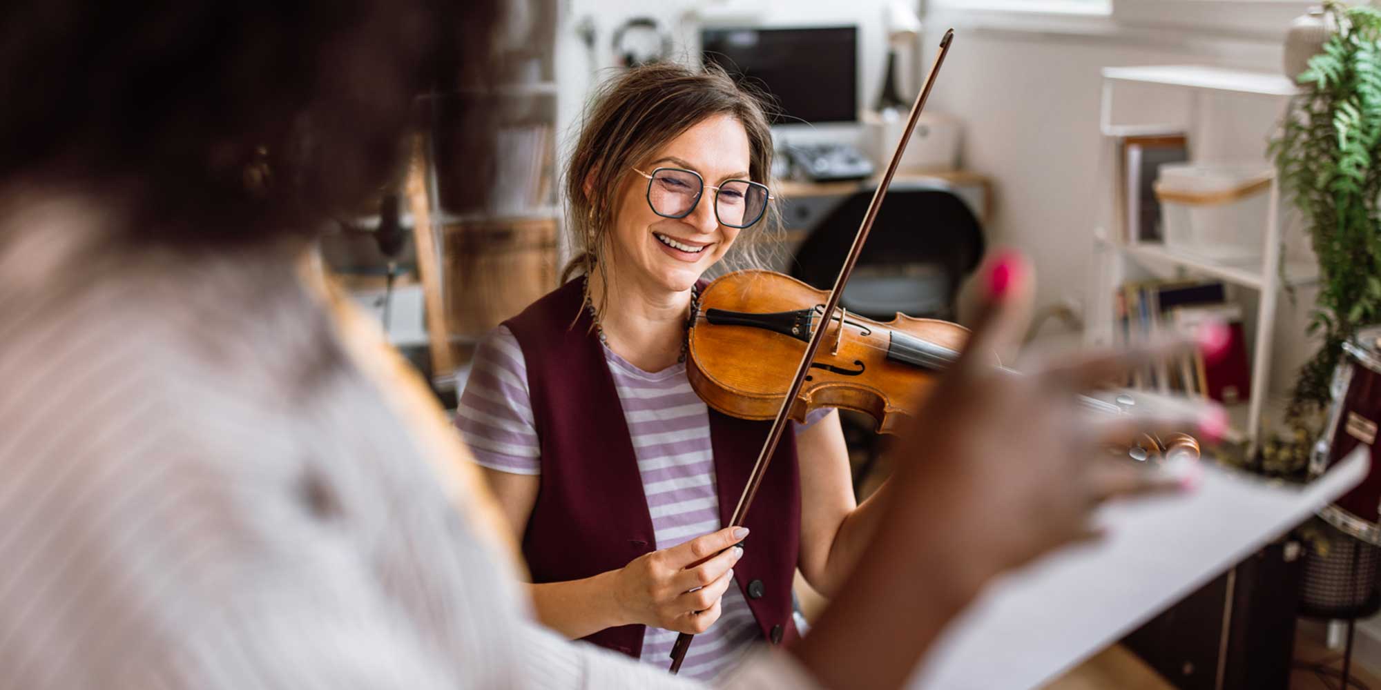 Music teacher instructing a student during a violin lesson
