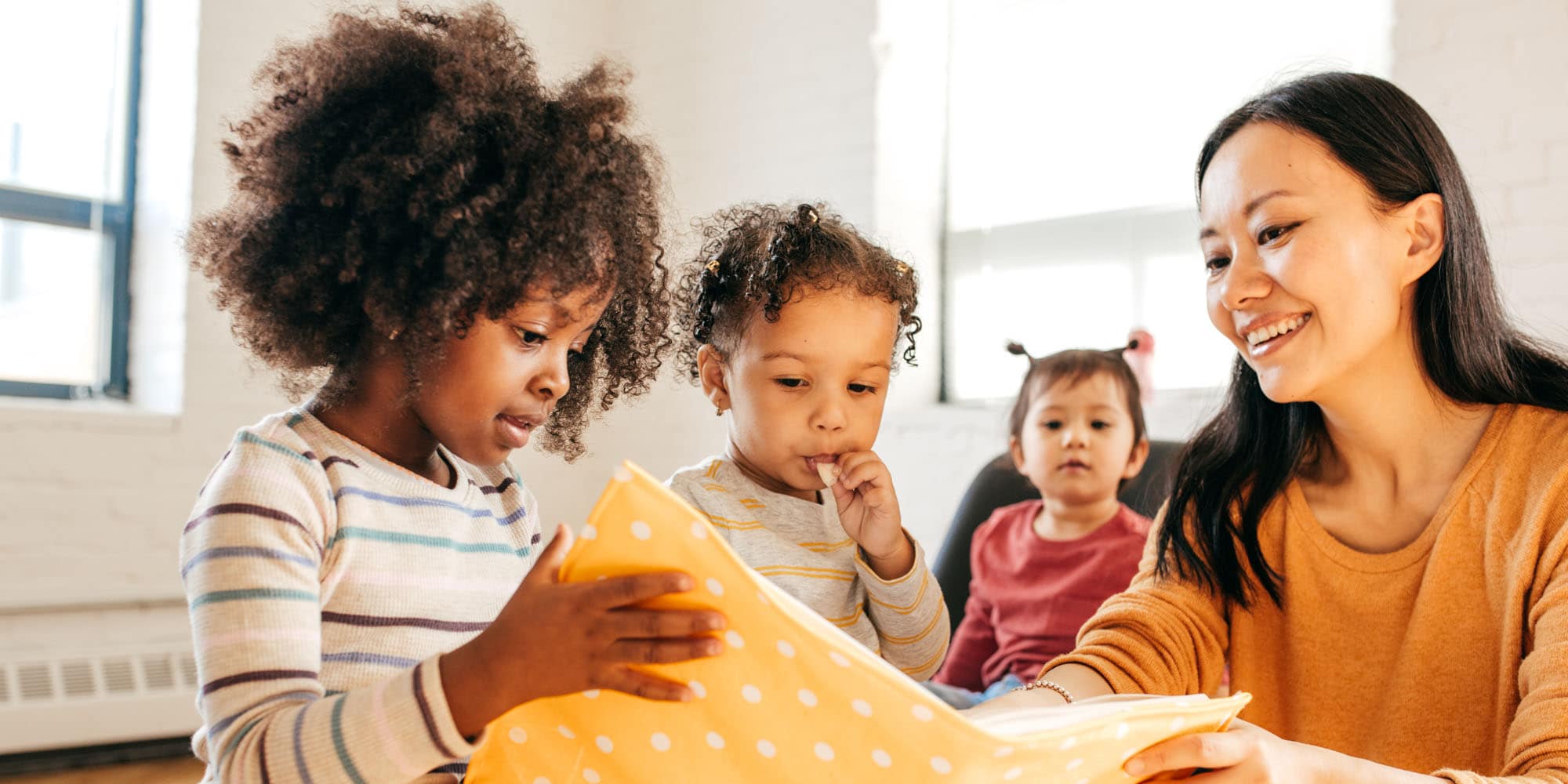 Woman reading a book with a small group of children