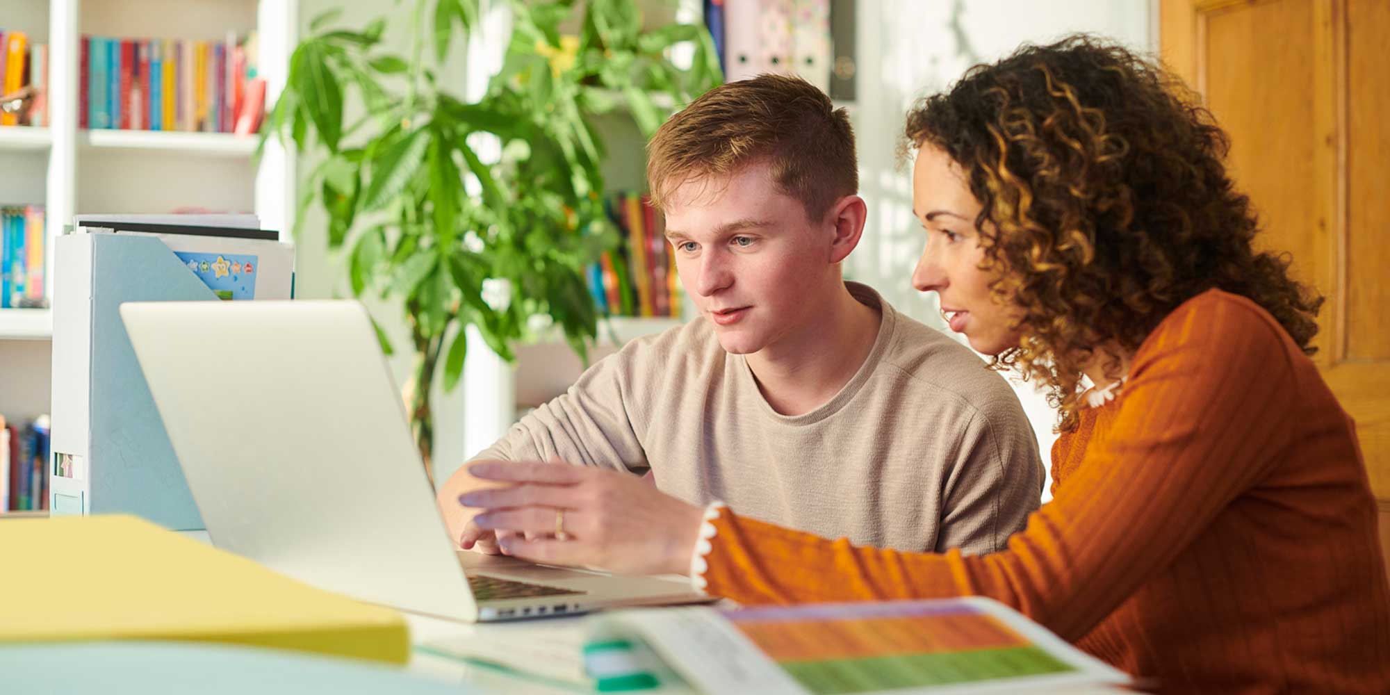 Teacher working one‑on‑one with a student at a laptop