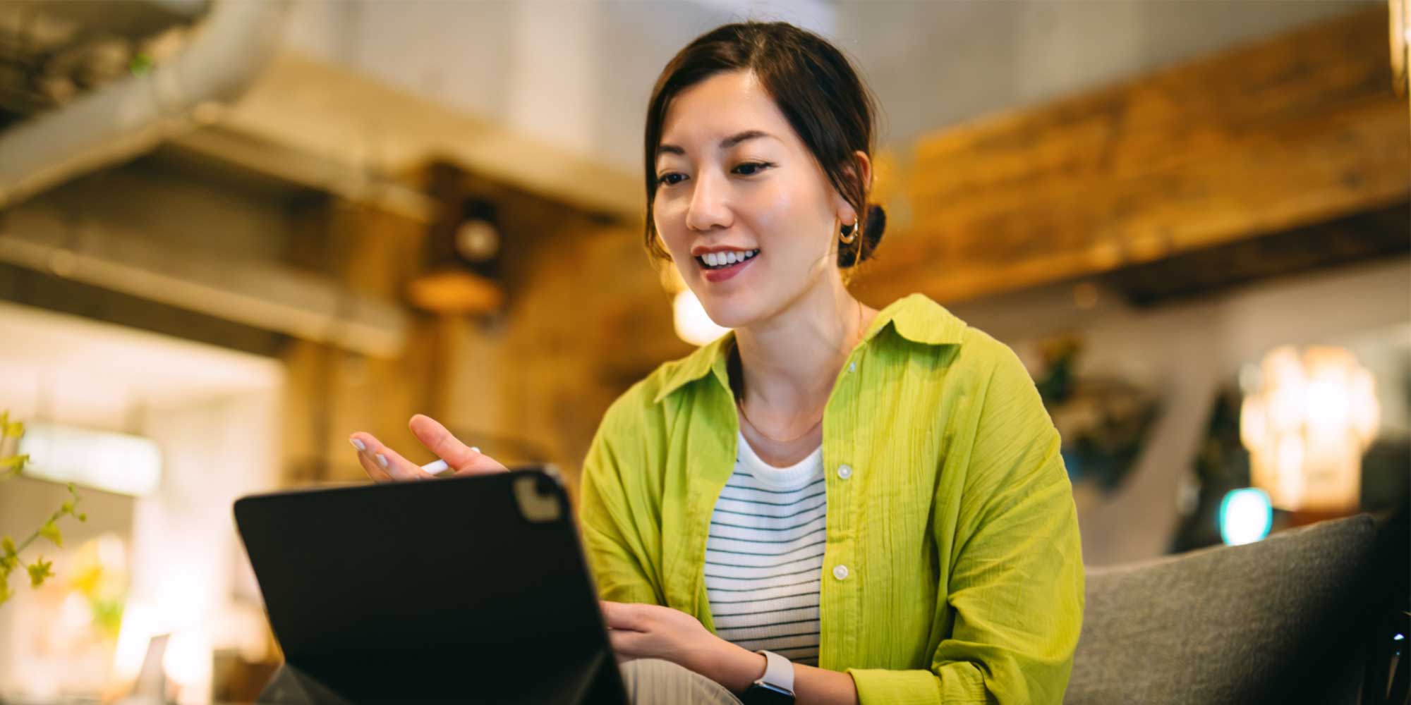 Person seated indoors using a tablet in a casual workspace